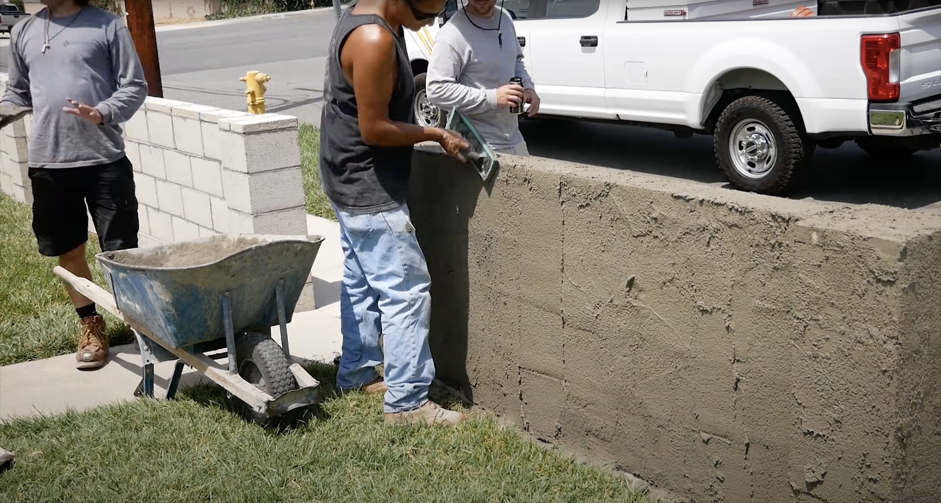 Professional concrete sidewalk installation and construction crew at work Concrete construction crew working on sidewalk installation with wheelbarrow and tools