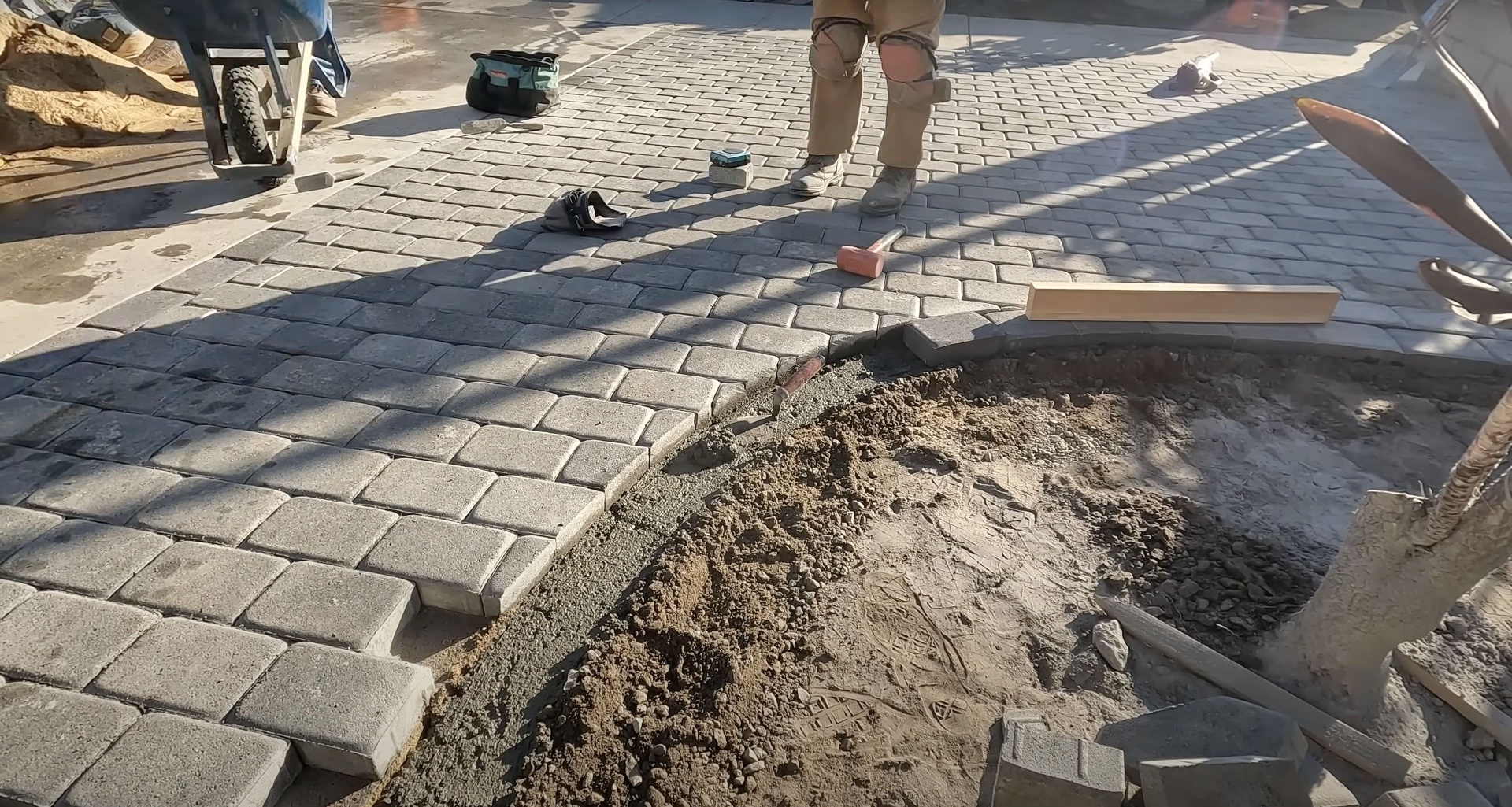 Detailed concrete paver installation and laying process Concrete paver installation in progress showing precision laying technique