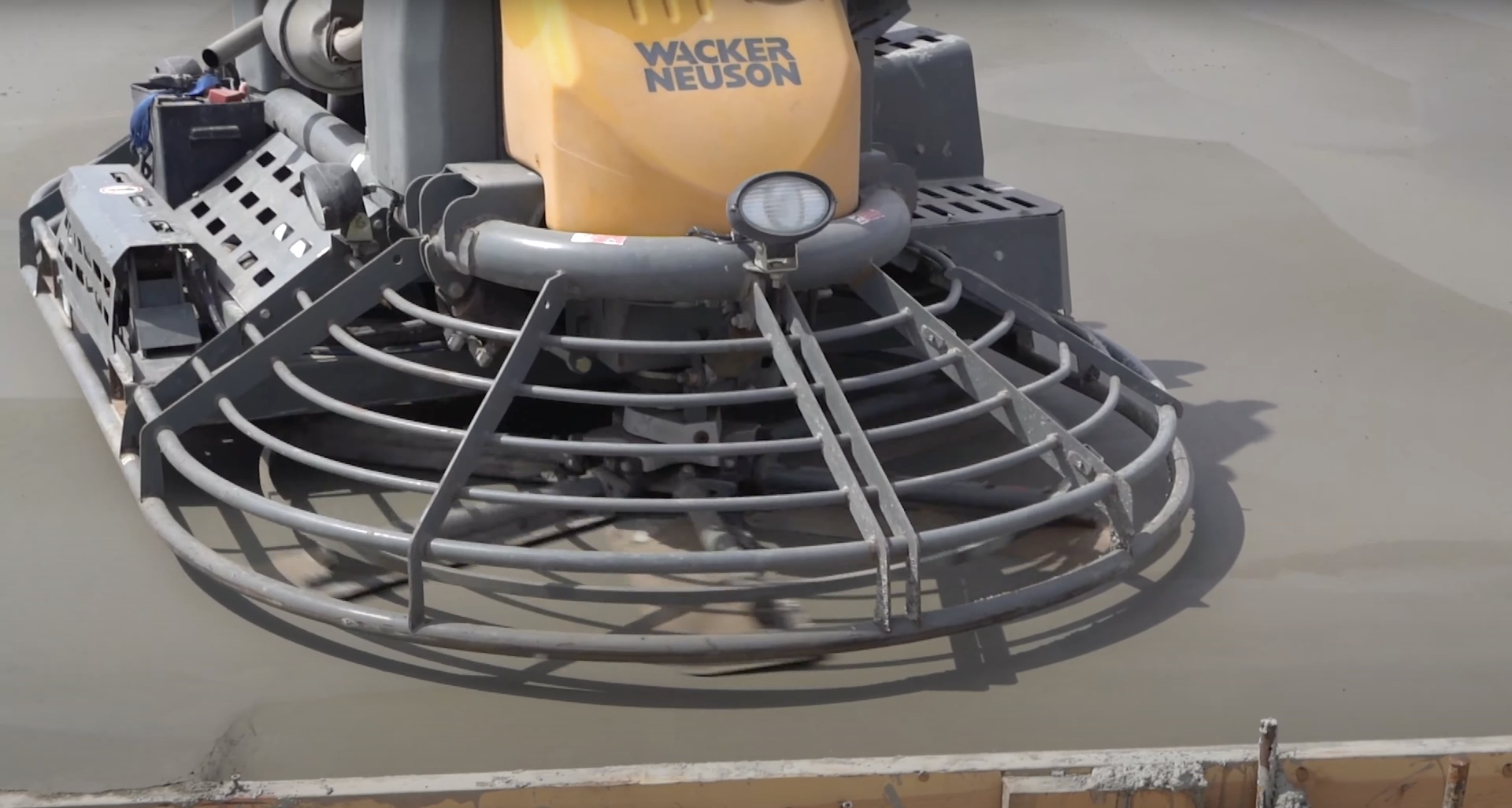 Professional concrete finishing equipment and techniques for large concrete surfaces Wacker Neuson concrete finishing equipment being used to smooth large concrete surface