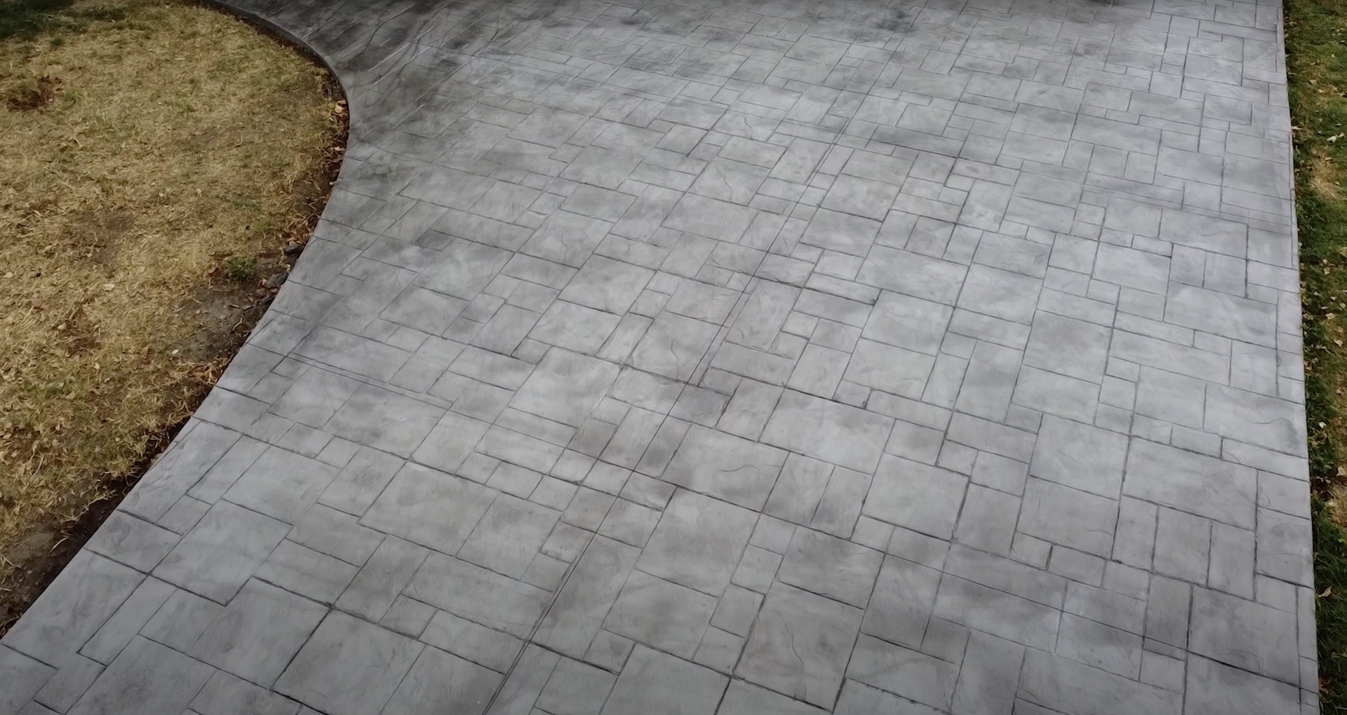 Professional concrete paver driveway installation in herringbone pattern Completed concrete paver installation showing herringbone pattern in residential driveway