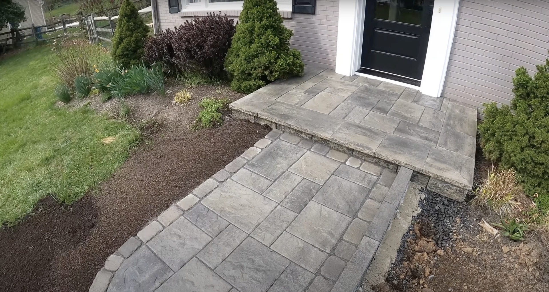 Professional concrete walkway and entrance paver installation Completed concrete walkway and entrance with decorative paver design